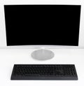 There is a monitor with a black screen and a non-black keyboard on a white table. Royalty Free Stock Photo