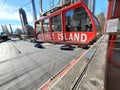 Roosevelt Island Tramway carriage shoves off from platform over traffic