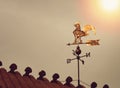 Rooster weather vane on sunset