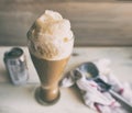 Root beer float in a tall pilsner glass, with ice cream scoop and soda can in the background. Royalty Free Stock Photo