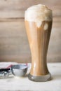 Root beer float in a tall pilsner glass, with vanilla ice cream melting, shown with thumb press disher. Royalty Free Stock Photo