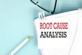ROOT CAUSE ANALYSIS text on a sticky on notebook with pen and glasses , blue background Royalty Free Stock Photo