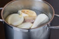 Root vegetables in soup in a pot. Carrots, parsley, celery, onions on a wooden cutting board Royalty Free Stock Photo