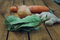 Roots garlic, onion, carrot, bay leaf lying on a wooden table Royalty Free Stock Photo
