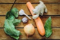 Roots garlic, onion, carrot, bay leaf lying on a wooden table Royalty Free Stock Photo