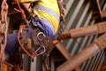 rope access inspector worker wearing full safety harness setting on a chair