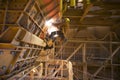 Rope access miner wearing safety harness helmet uniform working at height on rope commencing gouging Royalty Free Stock Photo