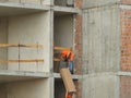 Rope access rigger worker commencing high risk job wearing heavy duty glove holding a safety tag line rope to control a load while Royalty Free Stock Photo