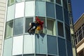 Rope access technician washes windows on the facade of a high-rise building