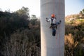 Rope access technician inspecting concrete bridge pillar using climbing equipment Royalty Free Stock Photo