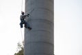 Rope access technician installing anchorages on concrete chimney Royalty Free Stock Photo