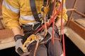 Rope access technician performing transferring his working rope from chest ascender to descender device Royalty Free Stock Photo