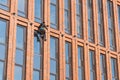 Rope access technician works on highrise building`s facade