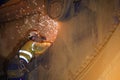 Rope access welder wearing personal protective equipment PPE while using electric grinding preparation