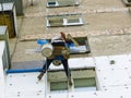 Rope access worker spreading mortar over styrofoam insulation Royalty Free Stock Photo