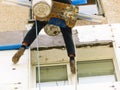Rope access worker spreading mortar over styrofoam insulation Royalty Free Stock Photo