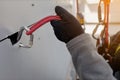 Rope access worker wearing black safety glove checking attachment rope on Karabiner to ensure is safety connecting into panel