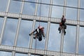 Rope access workers clean windows in office building