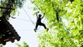 Rope adventure in forest - woman walks on ropes