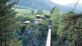 Rope bridge to the island over a mountain stream Royalty Free Stock Photo