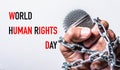 Rope and chain on fist hand with world HUMAN RIGHTS DAY text Royalty Free Stock Photo