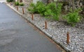 A rope fence in a city park protects flower beds from the entrance of people dogs or bicycle entry into flower beds separates lawn