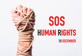 Rope on fist hand with SOS HUMAN RIGHTS DAY 10 december text Royalty Free Stock Photo