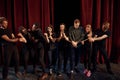 With rope in hands. Group of actors in dark colored clothes on rehearsal in the theater Royalty Free Stock Photo