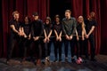 With rope in hands. Group of actors in dark colored clothes on rehearsal in the theater Royalty Free Stock Photo