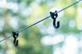 A rope with hooks for drying clothes during a hike is stretched between the trees in the forest. A tourist camp in the wild. Hooks Royalty Free Stock Photo