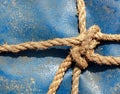 Rope knot on the dirty canvas background.