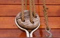 Rope with a knotted end tied around a cleat on a wooden pier - Nautical rope Royalty Free Stock Photo