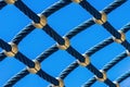 Rope mesh against a bright blue sky closeup, climbing park, playground for play and sport Royalty Free Stock Photo