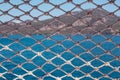 Rope net texture against blue sea background. A material net that is a decoration on a yacht, performing protective Royalty Free Stock Photo