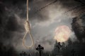 Rope noose with knot and misty cemetery on full moon night Royalty Free Stock Photo