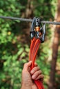 Rope park. The hand hooks the carabiners to the belay line. Close-up.