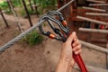 Rope park. The hand hooks the carabiners to the belay line. Close-up.