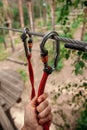 Rope park. The hand hooks the carabiners to the belay line. Close-up.