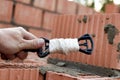 Rope plumb for even brickwork. Compliance with the correct laying of walls and corners of ceramic bricks. Bricklayer's tool Royalty Free Stock Photo