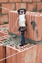 Rope plumb for even brickwork. Compliance with the correct laying of walls and corners of ceramic bricks. Bricklayer\'s tool Royalty Free Stock Photo