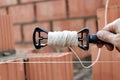 Rope plumb for even brickwork. Compliance with the correct laying of walls and corners of ceramic bricks. Bricklayer's tool Royalty Free Stock Photo