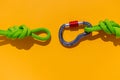 rope with a secure knot and a carabiner lies on a colored background. Equipment for rock climbing and mountaineering. reliable