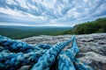 A rope is seen on top of a rugged mountain, serving as a safety measure for climbers, A dramatic view from the top of a rock Royalty Free Stock Photo