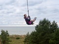 Rope swing over the sea, girl swinging on a swing Royalty Free Stock Photo