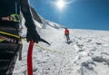 Rope team descending Mont Blanc Monte Bianco summit 4,808m dressed mountaineering clothes walking by snowy slopes with ice axe Royalty Free Stock Photo