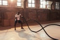 Rope workout. Sport man doing battle ropes exercise at gym Royalty Free Stock Photo