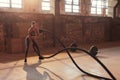 Rope workout. Sport woman doing battle ropes exercise at gym Royalty Free Stock Photo