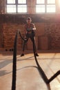 Rope workout. Sport woman doing battle ropes exercise at gym Royalty Free Stock Photo