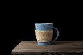 Rope wrapped around coffee cup on wooden desk