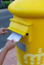 Roquetas de Mar, Spain; September 27th 2021: Hands of woman throwing a letter in a yellow mailbox